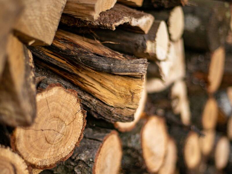 Ein Stapel geschnittener Holzscheite liegt dicht beieinander.